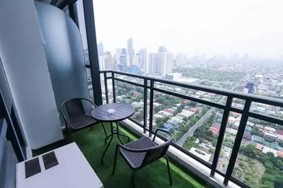 a balcony with a table and chairs in a building at Spacious and Cozy 2 Br in The Gramercy Poblacion in Manila