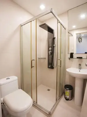 a bathroom with a shower and a toilet and a sink at High Floor 2BR in Knightsbridge Residences Makati in Manila
