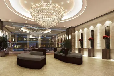 a lobby with a chandelier and couches in a building at Cozy 2BR Unit in FAME Residences, Mandaluyong City in Manila
