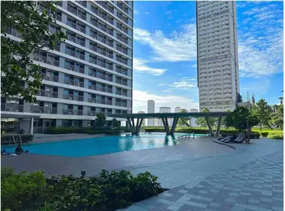 a bridge over a swimming pool in a building at Cozy 2BR Unit in FAME Residences, Mandaluyong City in Manila