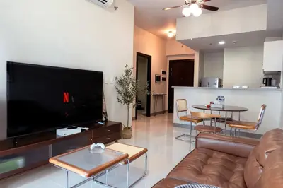 a living room with a couch and a large television at Parksuites BGC - Spacious 2 Bedroom in Manila