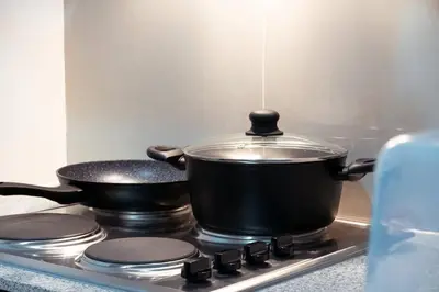 two pots and pans on a stove in a kitchen at Parksuites BGC - Spacious 2 Bedroom in Manila