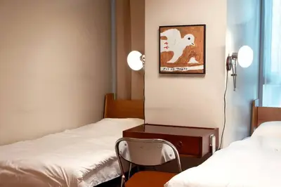 a room with two beds and a chair in it at Parksuites BGC - Spacious 2 Bedroom in Manila