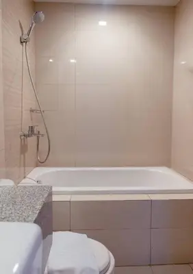 a bathroom with a white tub and a toilet at Parksuites BGC - Spacious 2 Bedroom in Manila