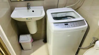 a washing machine and a sink in a bathroom at Homey Staycation at MOA Complex in Manila