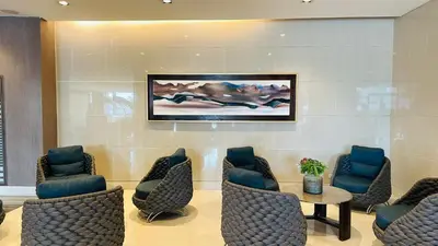 a waiting room with chairs and a painting on the wall at Homey Staycation at MOA Complex in Manila