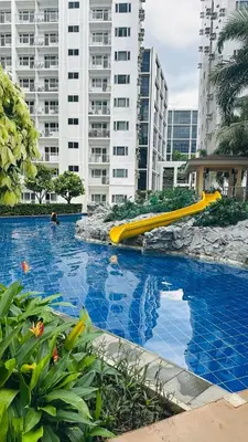 a swimming pool with a slide in a city at Homey Staycation at MOA Complex in Manila