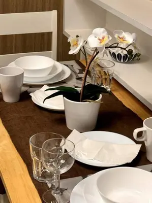 a table with plates and glasses and a plant on it at Daisy's Suite by Staycation in Manila