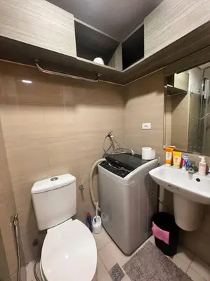 a small bathroom with a toilet and a sink at Daisy's Suite by Staycation in Manila