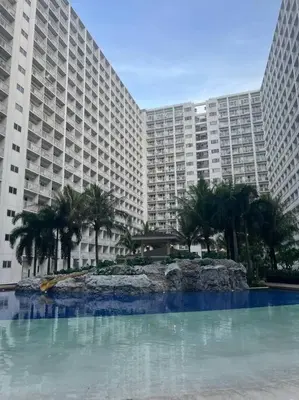 a large building with palm trees in front of it at Daisy's Suite by Staycation in Manila