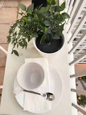 a white table with a plant and a plate and spoon at Daisy's Suite by Staycation in Manila