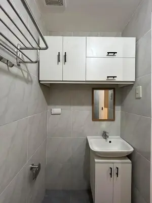 a white bathroom with a sink and a mirror at Casa Zahra in Manila
