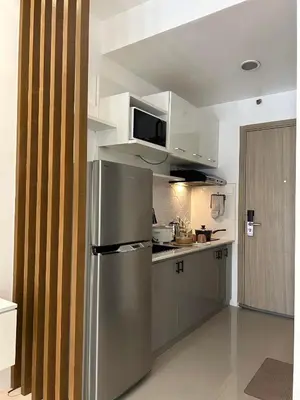 a kitchen with a stainless steel refrigerator and white cabinets at Casa Zahra in Manila
