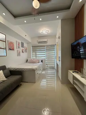 a bedroom with a bed and a flat screen tv at Casa Zahra in Manila