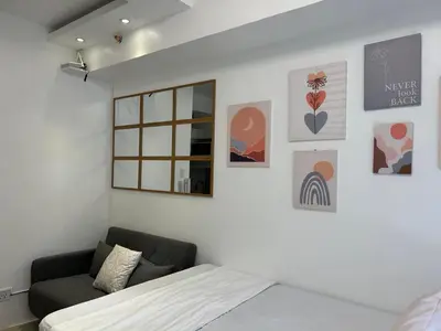 a bedroom with a bed and a window and a couch at Casa Zahra in Manila