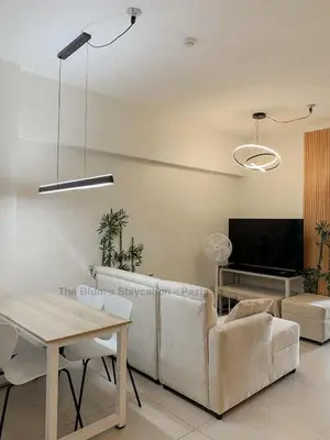 a living room with a couch and a tv at 2BR The Blums at Prisma Residences in Manila