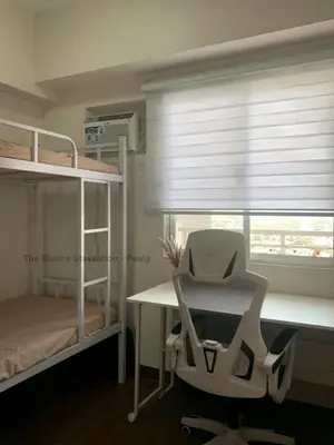 a bedroom with a desk and a chair and a window at 2BR The Blums at Prisma Residences in Manila