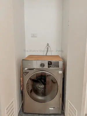 a washing machine in the corner of a room at 2BR The Blums at Prisma Residences in Manila
