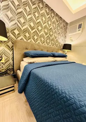 a bedroom with a blue bed and a wall at BEAUTIFUL and SPACIOUS 2 REAL BEDROOMS 2 BATHROOMS IN BGC GLOBAL CITY in Manila