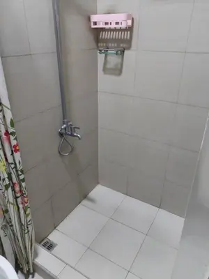 a bathroom with a shower with a tile floor at Shore 2 Family Suite 2 Beds Balcony City View WiFi Netflix MOA 735 in Manila