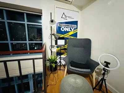 a room with a chair and a sign on the wall at Newly Renovated 2-storey Loft at Greenbelt 1 in Manila