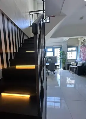 a living room with a staircase in a house at Newly Renovated 2-storey Loft at Greenbelt 1 in Manila