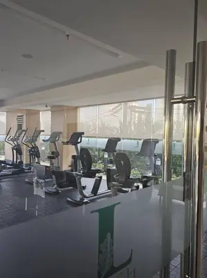 a gym with a row of treadmills in a room at Happy Haven at Lush Makati in Manila