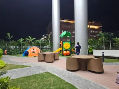 a man standing next to a playground with tables and chairs at Alexa Smart Home l Balcony Night View l Fast Wifi in Manila