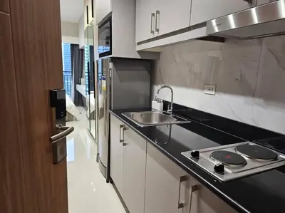 a kitchen with a sink and a stove at Alexa Smart Home l Balcony Night View l Fast Wifi in Manila