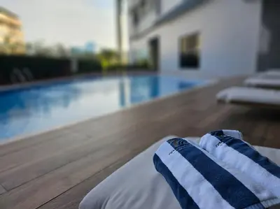a close up of a bed next to a swimming pool at Alexa Smart Home l Balcony Night View l Fast Wifi in Manila