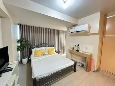 a bedroom with a bed and a television in it at Eastwood Global Plaza Luxury 1Bed Room with 2 Toilets and Laundry Room in Manila