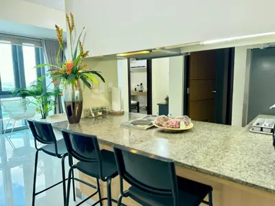 a kitchen with a island with chairs and a counter top at Eastwood Global Plaza Luxury 1Bed Room with 2 Toilets and Laundry Room in Manila