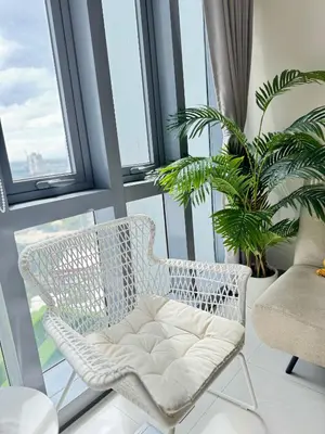 a white chair sitting on a balcony with a plant at Eastwood Global Plaza Luxury 1Bed Room with 2 Toilets and Laundry Room in Manila
