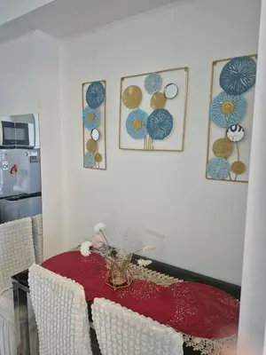 a dining room with a red table and some pictures on the wall at CHILL City Escapes at Azure Urban Residences in Manila