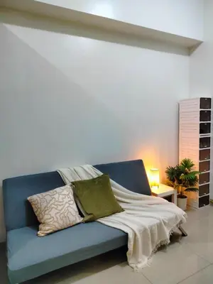 a blue couch with pillows in a room at SMDC StayWise Space in Manila