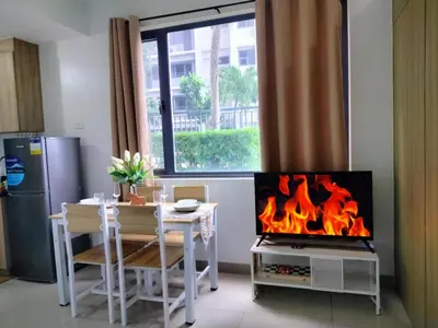 a living room with a table and a fireplace at SMDC StayWise Space in Manila