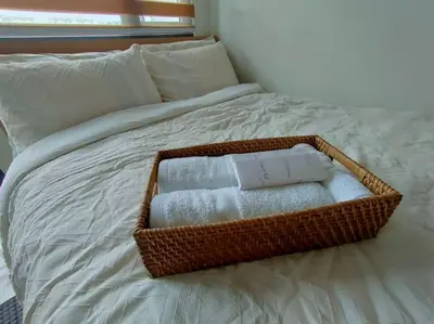 a basket of towels sitting on top of a bed at Casa Florentino in Manila