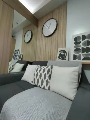 a living room with two clocks on the wall and a couch at Casa Florentino in Manila