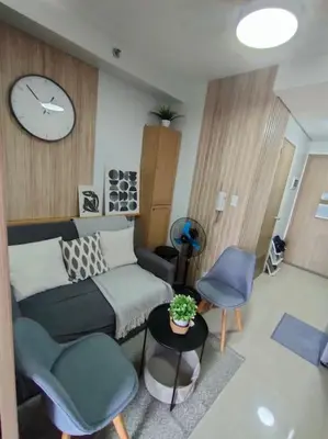 a living room with a couch and chairs and a clock at Casa Florentino in Manila