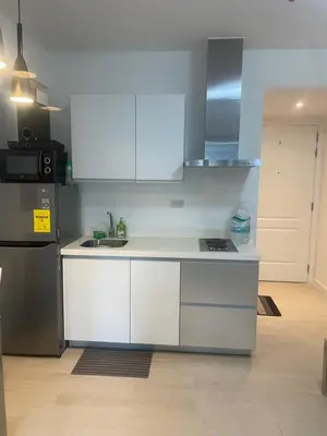 a kitchen with white cabinets and a stainless steel refrigerator at Azure Urban Residences Bahamas & One bedroom in Manila
