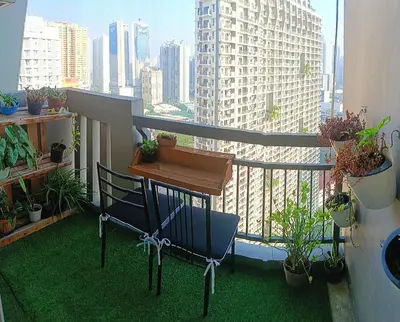 a balcony with a table and chairs and plants at Condominium in Manila