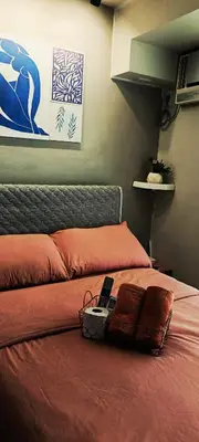 a bed with a cell phone sitting on top of it at Condominium in Manila