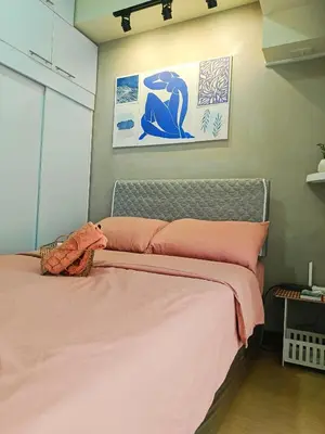 a bedroom with a bed with pink sheets at Condominium in Manila