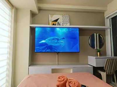 a bedroom with a flat screen tv on a wall at Condominium in Manila