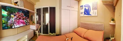 a living room with a couch and a flat screen tv at Condominium in Manila