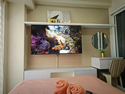 a bedroom with a flat screen tv on a wall at Condominium in Manila