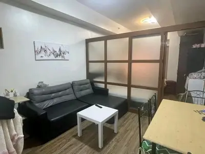 a living room with a black couch and a table at One taft residence taft avenue City Land manila in Manila