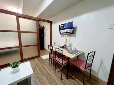 a room with a table and chairs and a tv at One taft residence taft avenue City Land manila in Manila