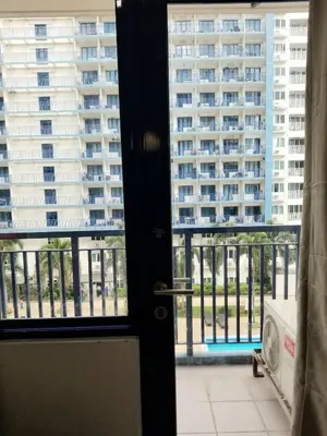 a door with a view of a large building at Sea residence Family Group Affordable staycation in Manila