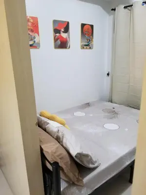 a small bed in a room with pictures on the wall at Sea residence Family Group Affordable staycation in Manila